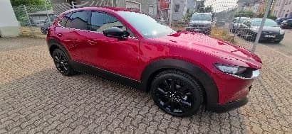 Roter Mazda CX-30 im Seitenprofil nach der Komplettversiegelung von Glas, Lack, Kunststoff und Felgen.