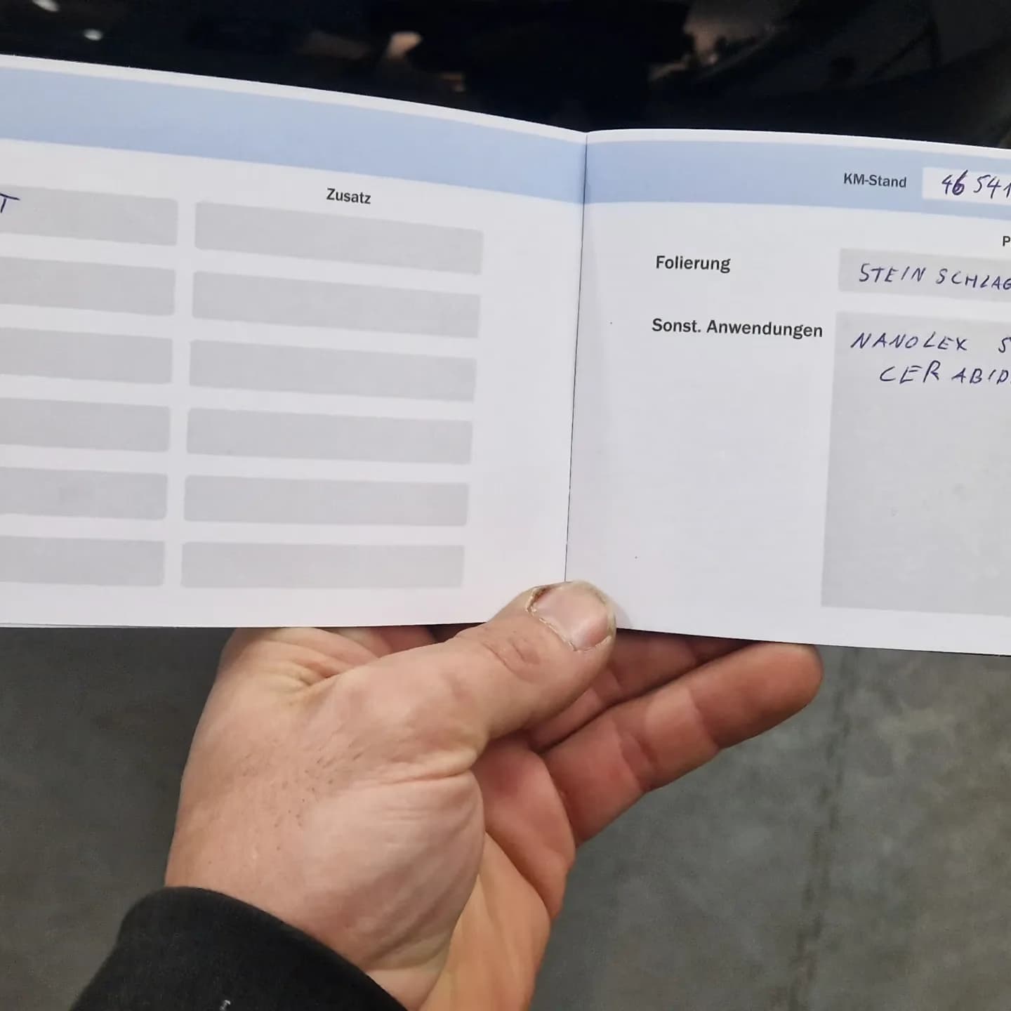 Aufgeschlagenes Detailing-Serviceheft mit handschriftlichen Einträgen zu Steinschlagschutzfolie und Nanolex SI3D Cerabide.